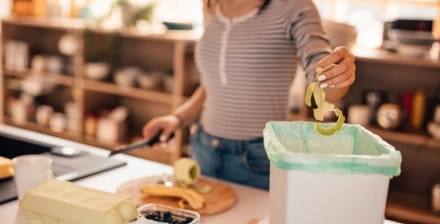 Mulher a preparar alimentos na cozinha, ilustrando o desperdício alimentar.