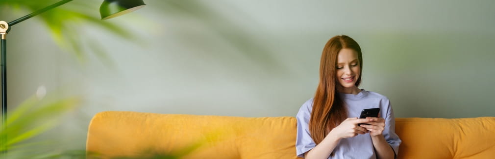 Uma rapariga jovem consulta um dicionário de seguros, no seu smartphone.