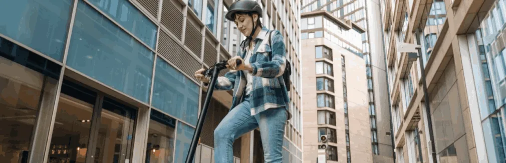 Jovem com capacete circula de trotinete elétrica