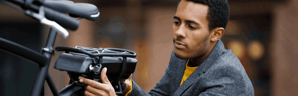 Jovem verifica a sua bicicleta elétrica antes de iniciar viagem